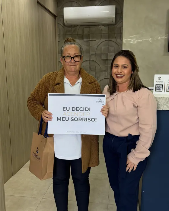 Paciente da Lumer com a placa Eu decidi meu sorriso